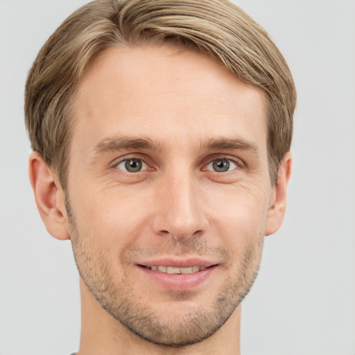 Joyful white young-adult male with short  brown hair and grey eyes