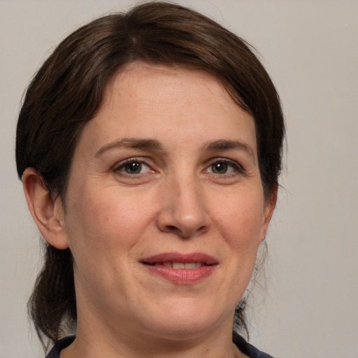 Joyful white adult female with medium  brown hair and brown eyes