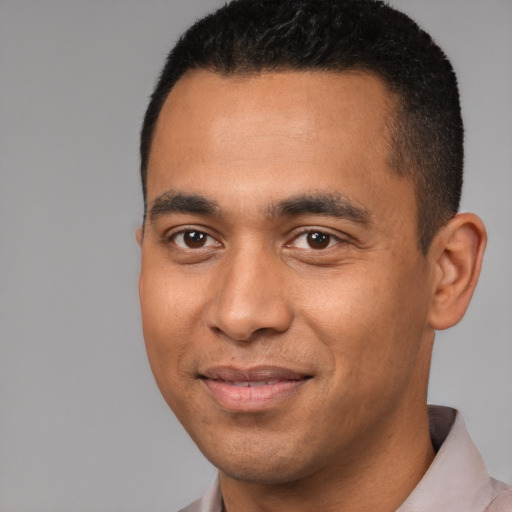 Joyful black young-adult male with short  brown hair and brown eyes