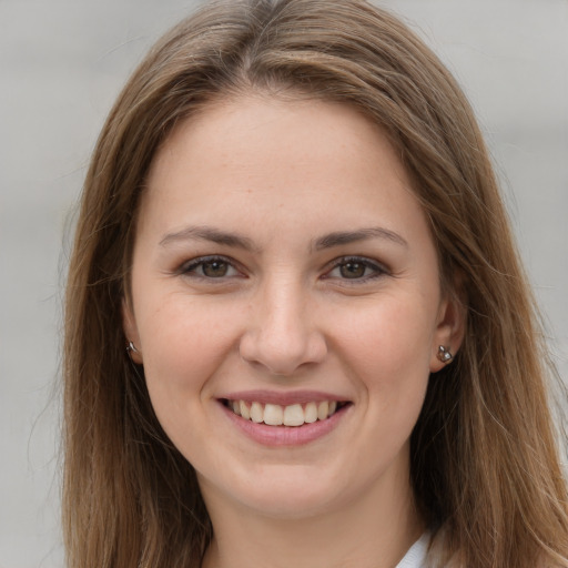 Joyful white young-adult female with long  brown hair and brown eyes