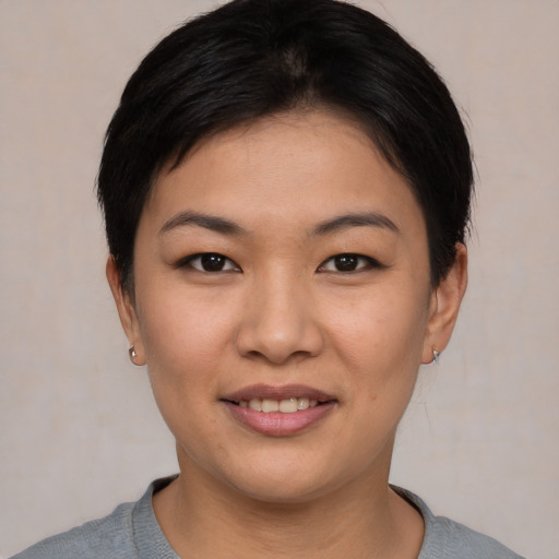 Joyful asian young-adult female with short  black hair and brown eyes