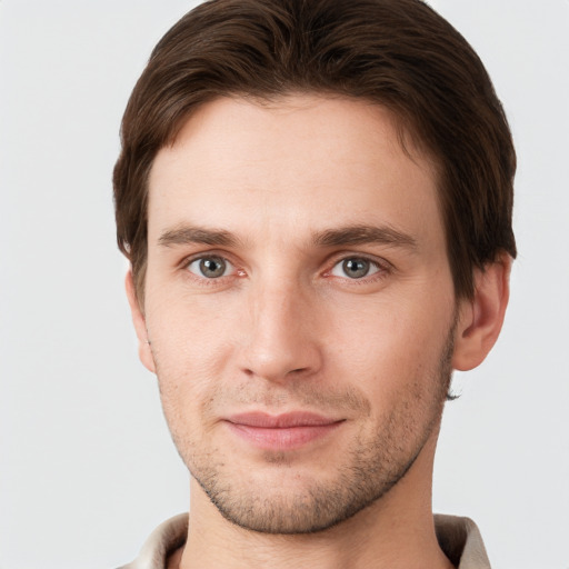 Joyful white young-adult male with short  brown hair and grey eyes