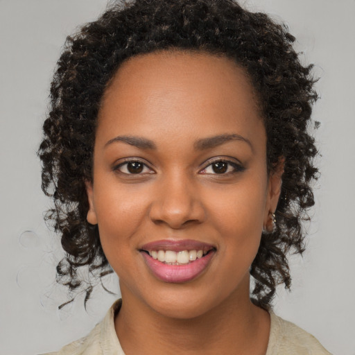 Joyful black young-adult female with medium  brown hair and brown eyes
