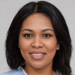 Joyful black young-adult female with long  brown hair and brown eyes