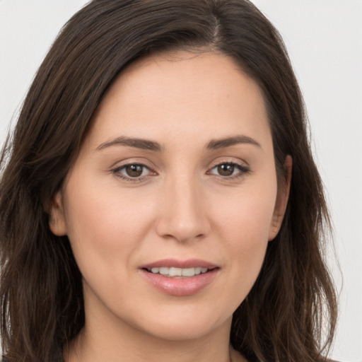 Joyful white young-adult female with long  brown hair and brown eyes