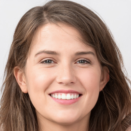 Joyful white young-adult female with long  brown hair and grey eyes