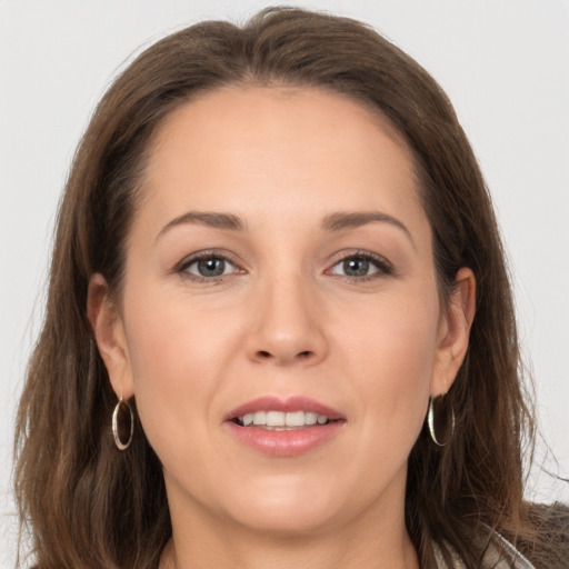 Joyful white young-adult female with long  brown hair and grey eyes