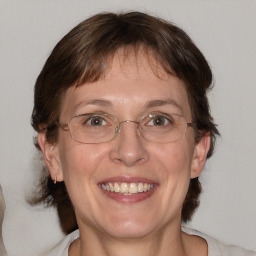 Joyful white adult female with medium  brown hair and blue eyes