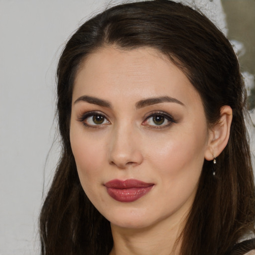 Joyful white young-adult female with long  brown hair and brown eyes