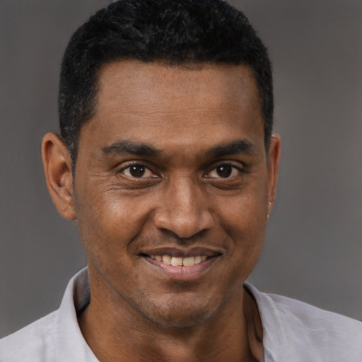Joyful black young-adult male with short  black hair and brown eyes