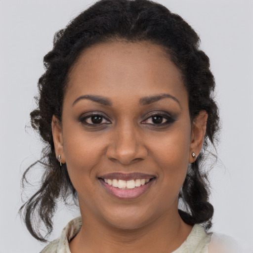 Joyful black young-adult female with long  brown hair and brown eyes