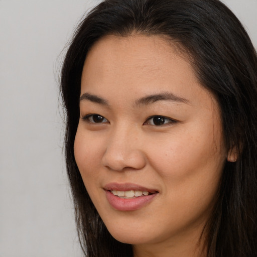 Joyful asian young-adult female with long  brown hair and brown eyes