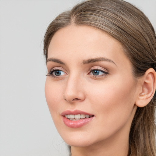 Joyful white young-adult female with long  brown hair and blue eyes