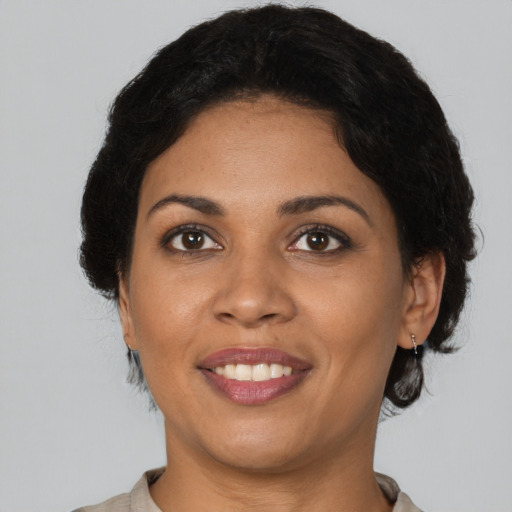 Joyful latino adult female with medium  brown hair and brown eyes