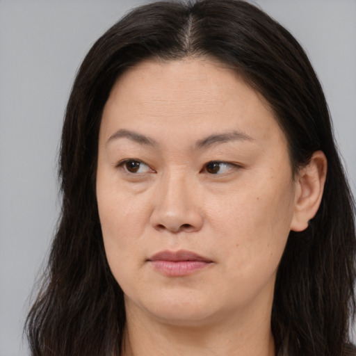 Joyful asian adult female with long  brown hair and brown eyes