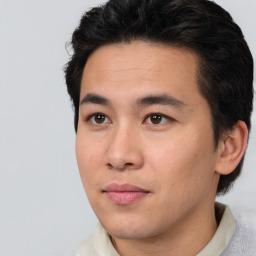 Joyful asian young-adult male with short  black hair and brown eyes