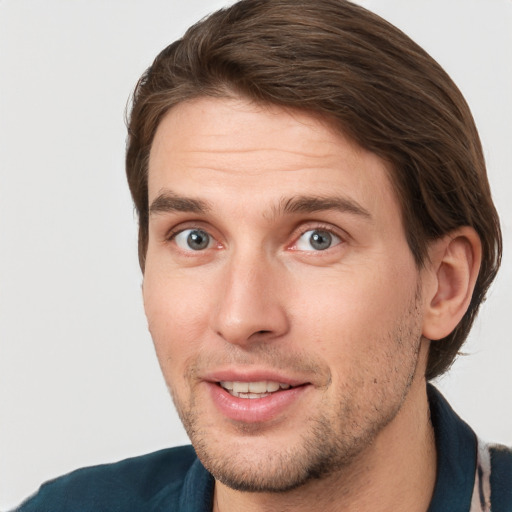 Joyful white young-adult male with short  brown hair and grey eyes