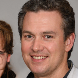 Joyful white adult male with short  brown hair and brown eyes