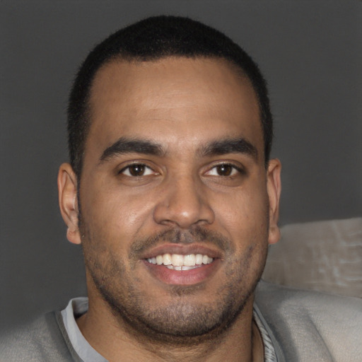 Joyful black young-adult male with short  brown hair and brown eyes