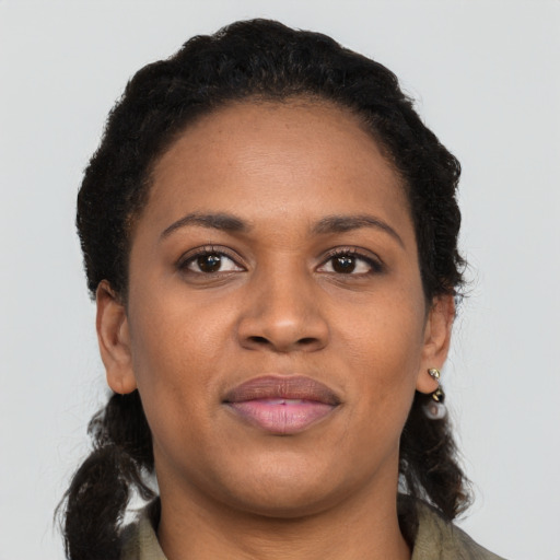 Joyful black young-adult female with long  brown hair and brown eyes