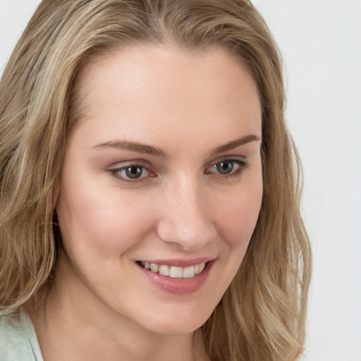 Joyful white young-adult female with long  brown hair and blue eyes