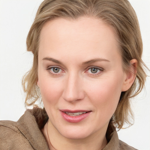 Joyful white young-adult female with medium  brown hair and blue eyes