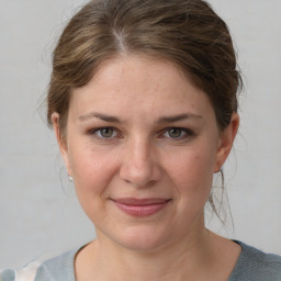 Joyful white young-adult female with medium  brown hair and grey eyes