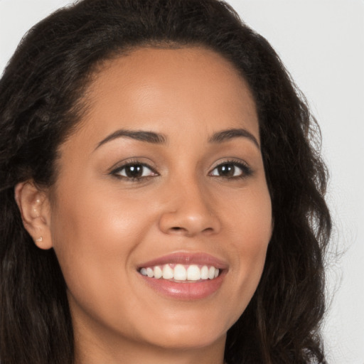 Joyful latino young-adult female with long  brown hair and brown eyes