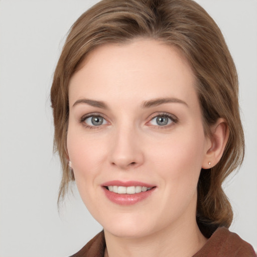 Joyful white young-adult female with medium  brown hair and blue eyes