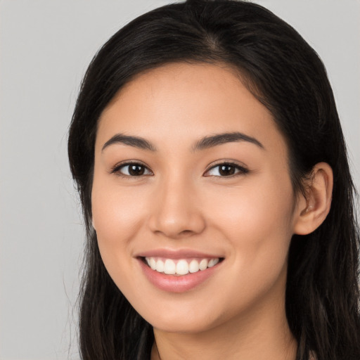 Joyful latino young-adult female with long  brown hair and brown eyes