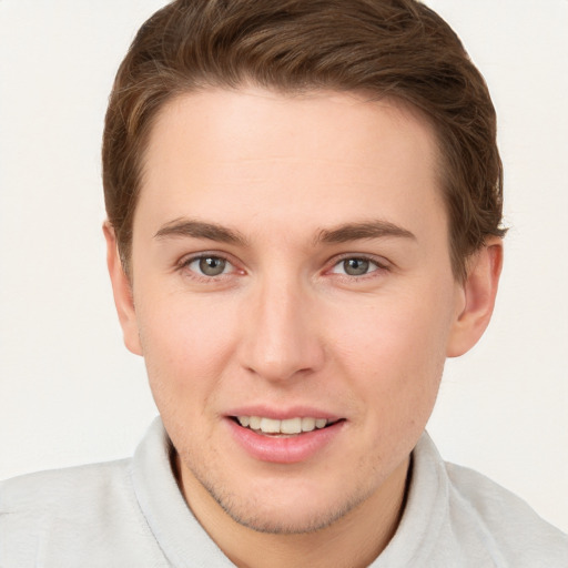 Joyful white young-adult male with short  brown hair and grey eyes