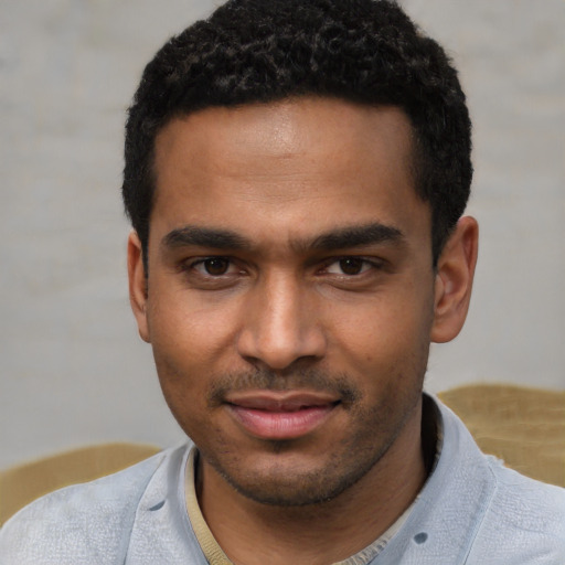 Joyful black young-adult male with short  black hair and brown eyes