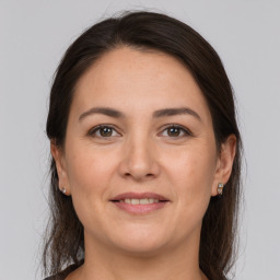 Joyful white young-adult female with medium  brown hair and grey eyes