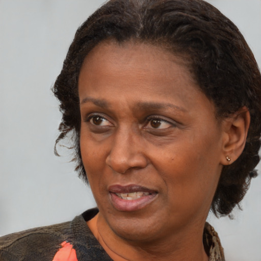 Joyful black adult female with medium  brown hair and brown eyes