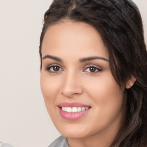 Joyful white young-adult female with long  black hair and brown eyes