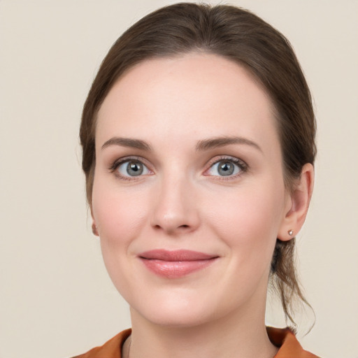 Joyful white young-adult female with medium  brown hair and grey eyes