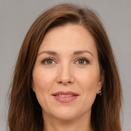 Joyful white adult female with long  brown hair and green eyes