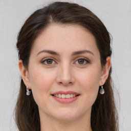 Joyful white young-adult female with long  brown hair and green eyes