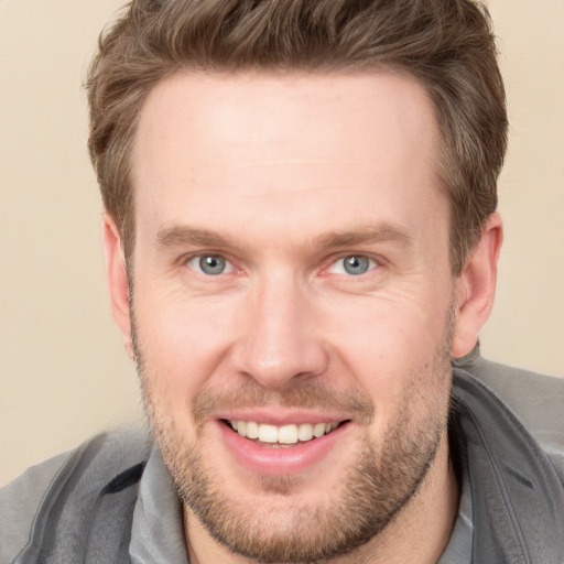 Joyful white adult male with short  brown hair and grey eyes