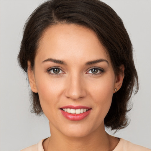 Joyful white young-adult female with medium  brown hair and brown eyes