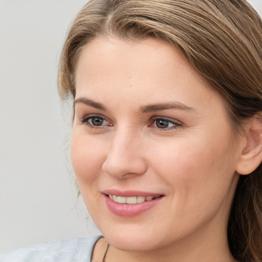 Joyful white young-adult female with long  brown hair and blue eyes