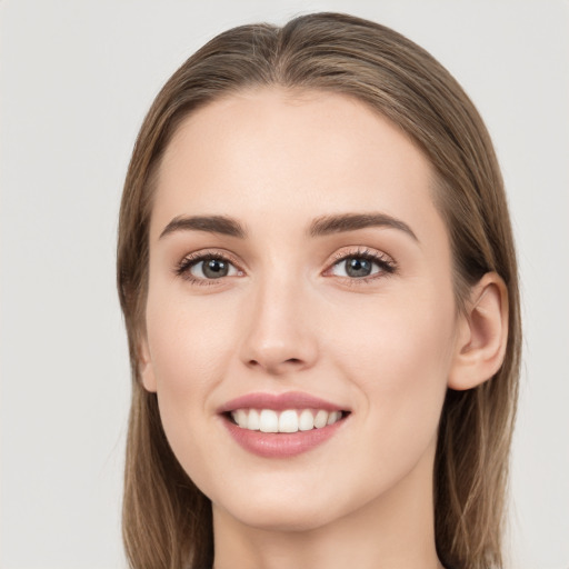 Joyful white young-adult female with long  brown hair and green eyes