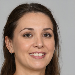 Joyful white adult female with long  brown hair and brown eyes