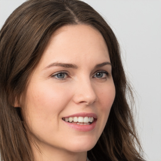 Joyful white young-adult female with long  brown hair and grey eyes