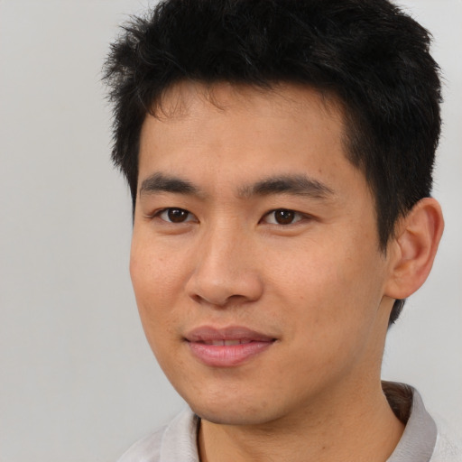 Joyful asian young-adult male with short  brown hair and brown eyes