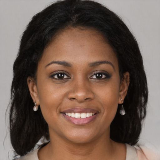 Joyful black young-adult female with long  brown hair and brown eyes