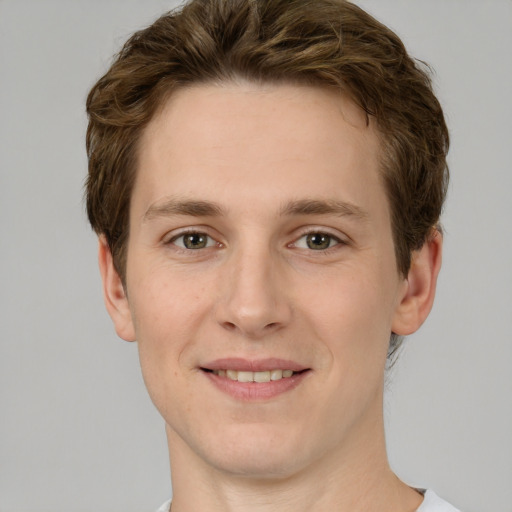 Joyful white young-adult male with short  brown hair and green eyes