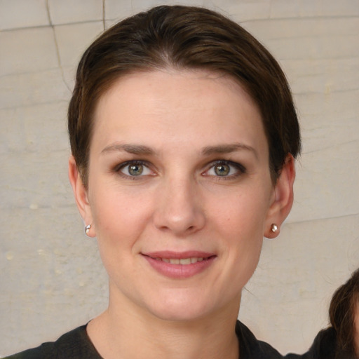 Joyful white young-adult female with short  brown hair and grey eyes