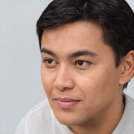 Joyful white young-adult male with short  black hair and brown eyes