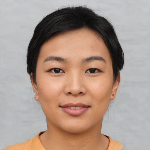 Joyful asian young-adult female with short  black hair and brown eyes